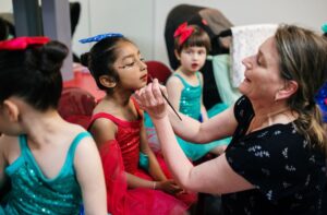 mother helping daughter get ready for dance performance